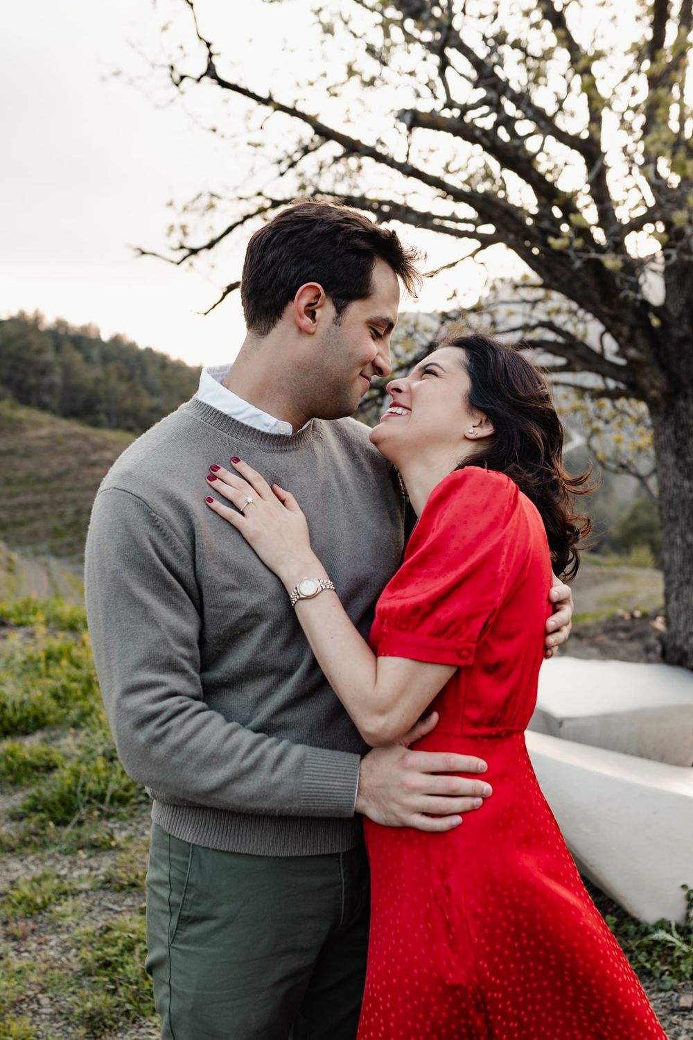 Una pareja abrazada; ella lleva un vestido rojo