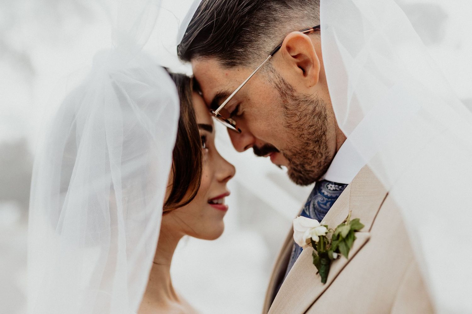 Los novios frente con frente bajo el velo